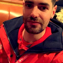 A man posing for a selfie with a cityscape in the background