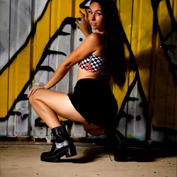 Ashley Wolf, a stunning model posing for an OnlyFans photoshoot in front of a vibrant wall.