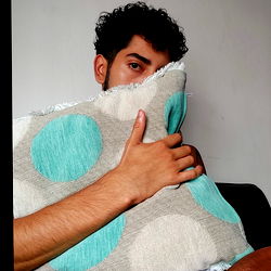 A model named Alex Vulcano, with an intriguing pose and expression, showcasing a fashionable aesthetic