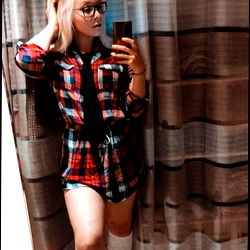 Onlyfans Alora in a cozy plaid pajama set posing against curtains for a casual and candid shot