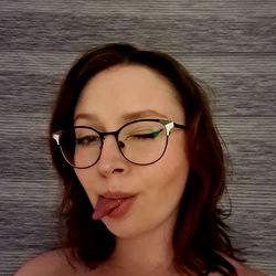 A Young Woman Making a Playful Tongue Out with Her Glasses