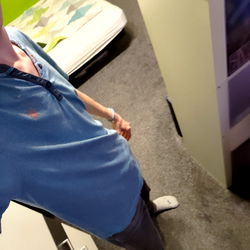 A Young Man in a Bright Blue Shirt Standing in a Room