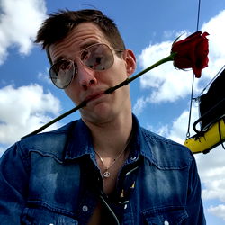 Rose-holding Man in Jeans and Sunglasses