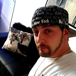 Young Man in Cap and Jewelry with Pillow in Background