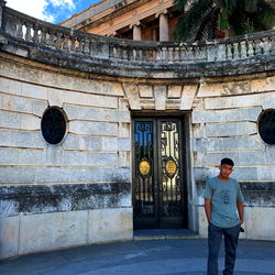 Young Man Standing in Front of a Historic Building