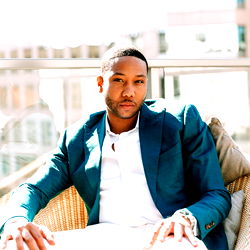 Model John Legendary in Suit, Sitting Outdoors