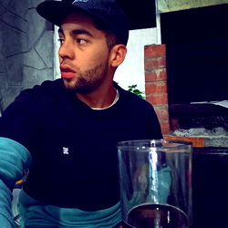 Man in Black Shirt and Hat, Sitting at Table