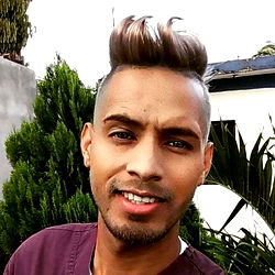 A Smiling Man in a Uniform Standing in Front of a Tree