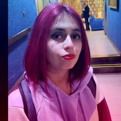 Stylish Woman with Vibrant Hair and Purple Jacket, Smiling at the Camera