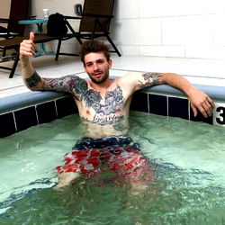 Tattooed Man Celebrating in a Hot Tub