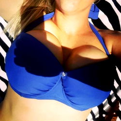 Model Alexiaaa lying on a beach towel in a blue bikini