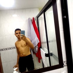 Person Standing in Bathroom Mirror