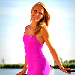 Blonde Beauty in Pink, Smiling at the Camera by a Lake