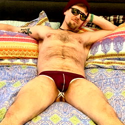 A Man in a Bikini Pose on Bed