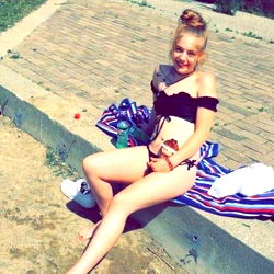 Ariel, a young and beautiful woman, relaxes on the beach in her bikini.