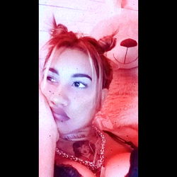 Intimate Moment of a Young Woman with Tattoos, Ponytails, and a Teddy Bear