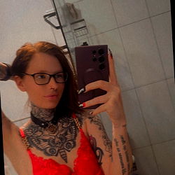 Model in Red Outfit with Tattoos and Piercings, Age 25, Gender Female