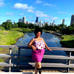 Charming Woman Poses for Photo at Bridge Overlooking River