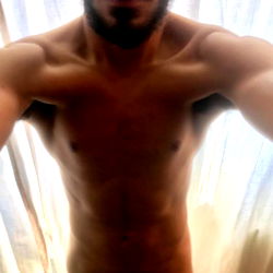 A Shirtless Man Taking a Selfie