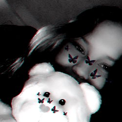 A girl with a teddy bear in front of her