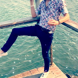 A Man Leaning on a Railing by the Water