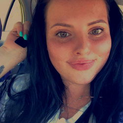 Amy, an OnlyFans model with black hair and blue eyes, posing for the camera.