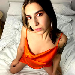 A young woman in a red dress posing on a bed