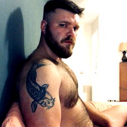 A Muscular Man with Tattoos in a Bathroom