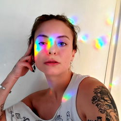 A woman in a white tank top with multiple colorful streaks behind her