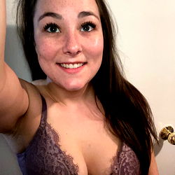 A young woman posing in a purple lingerie
