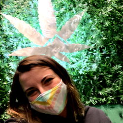 A Smiling Model Posing with a Huge Lit Leaf