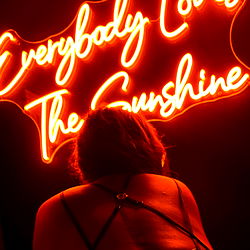 Model Posing in Front of Neon Sign