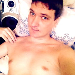 Alex, a young man taking a selfie in his bedroom