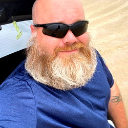 A Bearded Man in a Blue Shirt Taking a Selfie