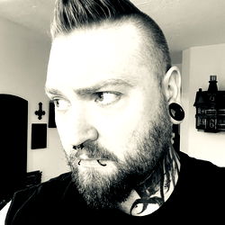 Bearded Man with Tattoos and Mohawk, Staring Seriously