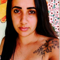 Young woman with tattoos, posing for a selfie.