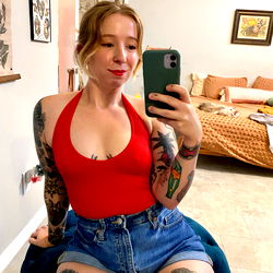 Young Woman with Tattoos and Red Top in Living Room
