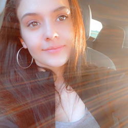 Smiling young woman in a car with a sunburst effect