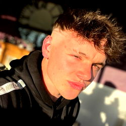 A Young Man with Short Hair, Posing in a Dark Room