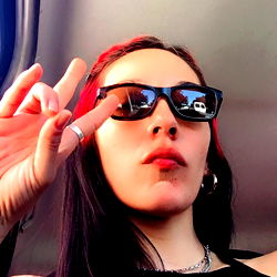 Tattooed Ailish Model Sharing a Peace Sign from Car