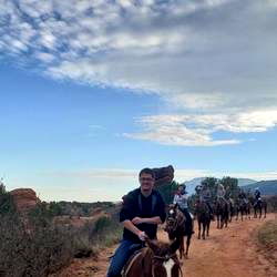 A Man Enjoying Horseback Riding in a Rocky Mountain Scenic Location