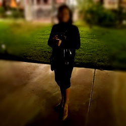 Woman in Black Dress Standing Outdoors