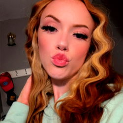 Amara from the United States, a stunning beauty with long red hair and vibrant makeup.