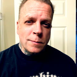 A Man with Tattoos and a Distinct Hairstyle