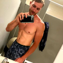 A Well-toned Man in a Bathroom Mirror