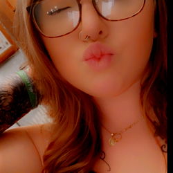 A woman with glasses posing for a photo