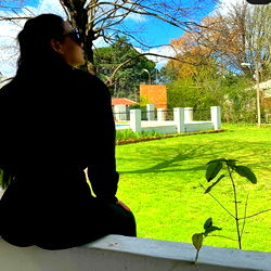 A Person Sitting on a Wall in an Outdoor Setting