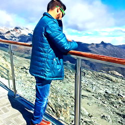 A Person Standing at the Edge of a Mountain