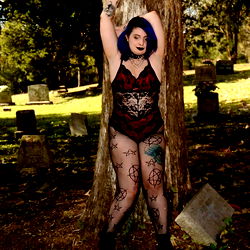 Fantastical Vampire-like Model in Kinky Fishnet Outfit Strikes a Pose