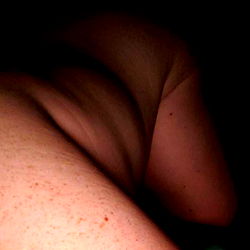 Female figure captured from rear, in a dark setting